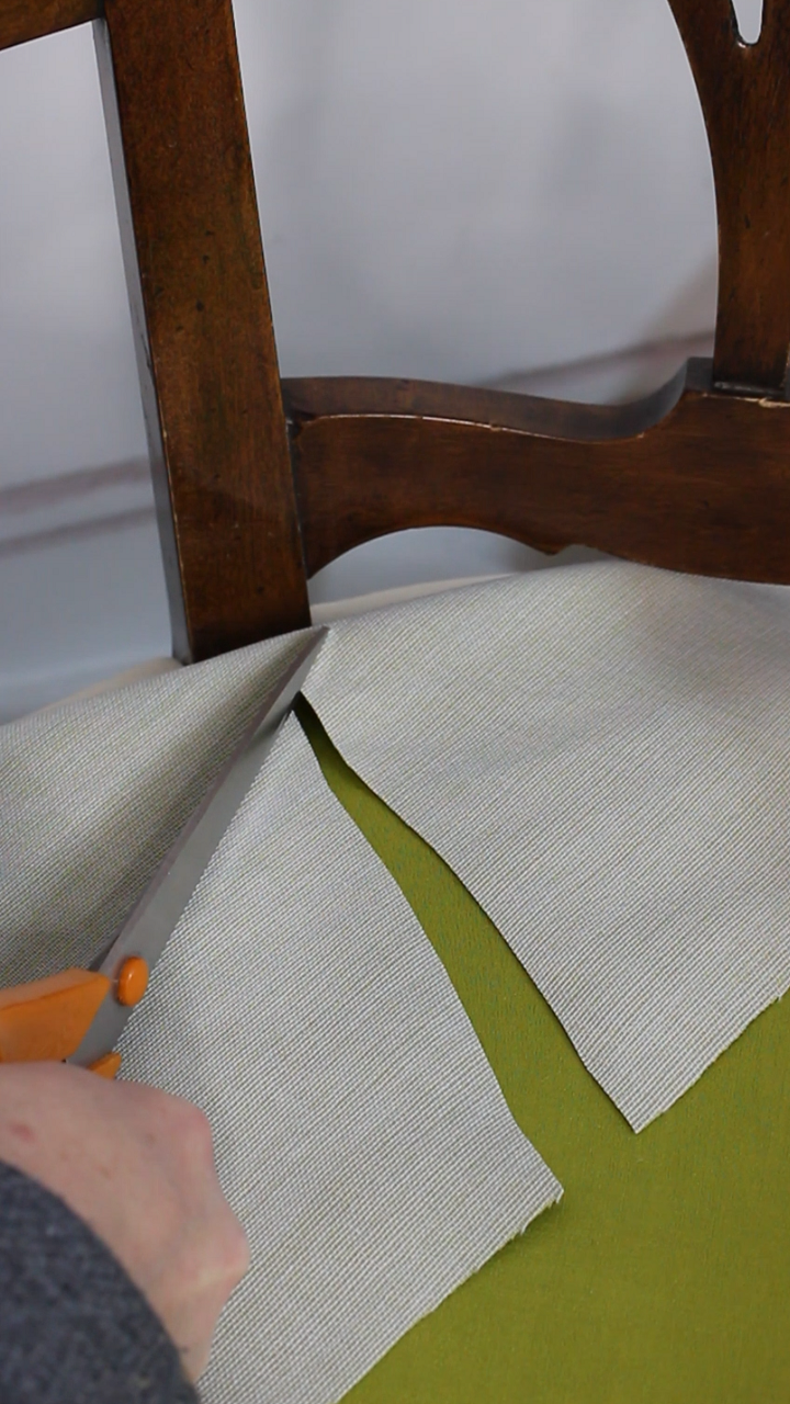 Gros plan sur une coupe en Y réalisée sur un tissu d'assise de fauteuil pour épouser parfaitement le montant du doossier. Explication des différentes coupes en tapisserie et de leur importance pour un résultat impeccable.