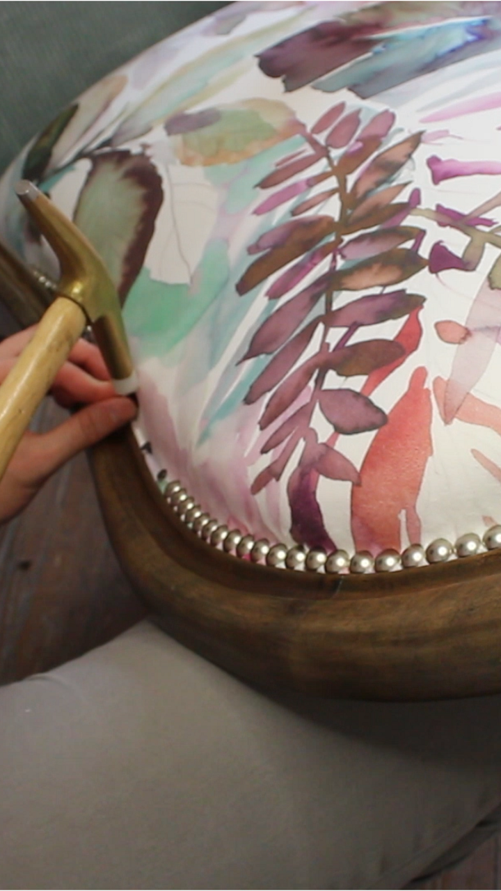 Pose des clous décoratifs sur le dossier d'un fauteuil Voltaire